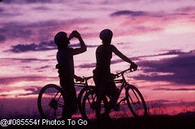 Silhouette of mountain bikers at sunset